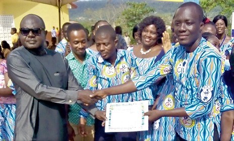 Charles Oware Tweneboah (left), Fanteakwa North District Chief Executive, presenting a certificate to Prince Asirifi Nyarko, the Overall Best Teacher